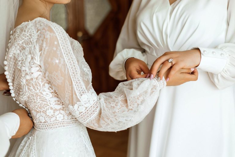 Mother of the bride doing up her wedding dress before giving a mother of the bride speech