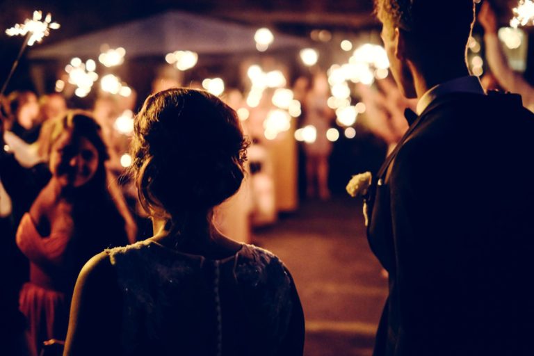 A bride and groom entering their wedding reception