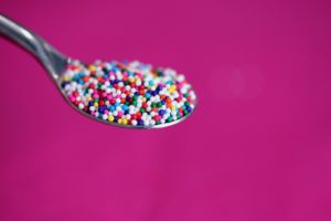 A spoon with coloured sprinkles