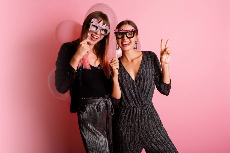 Two girls wearing wedding photo booth props