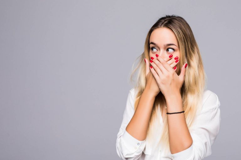 A woman covering her mouth because she answered the never have i ever questions at a hen party