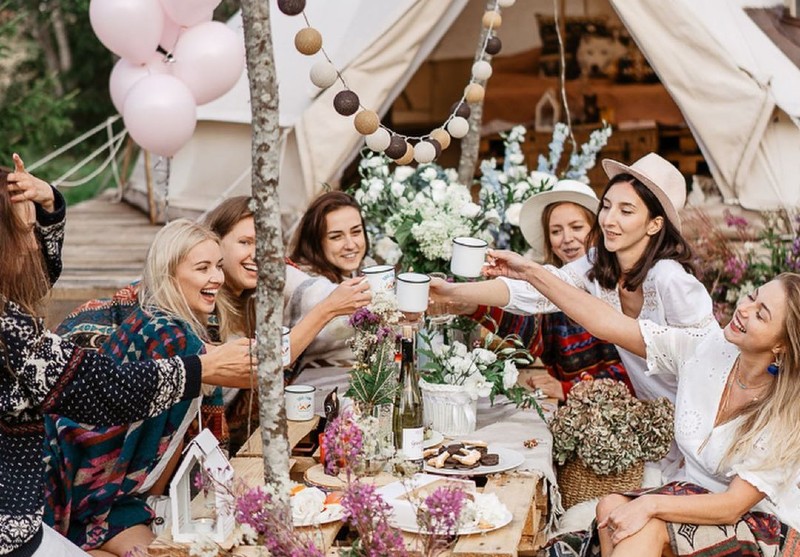 A picnic showing boho hen party decoration ideas like balloons and flowers