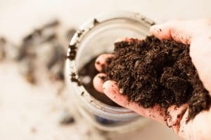A woman pouring soil into a unity dirt jar