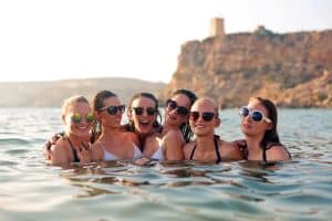 A group of girls in the water at the beach on a hen party abroad