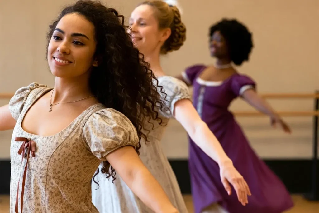 Women dancing in a Bridgerton hen party dance class wearing regency costumes